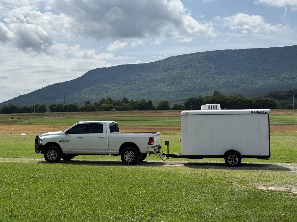 The C&J Aviation truck and enclosed shop trailer parked at a grass airstrip